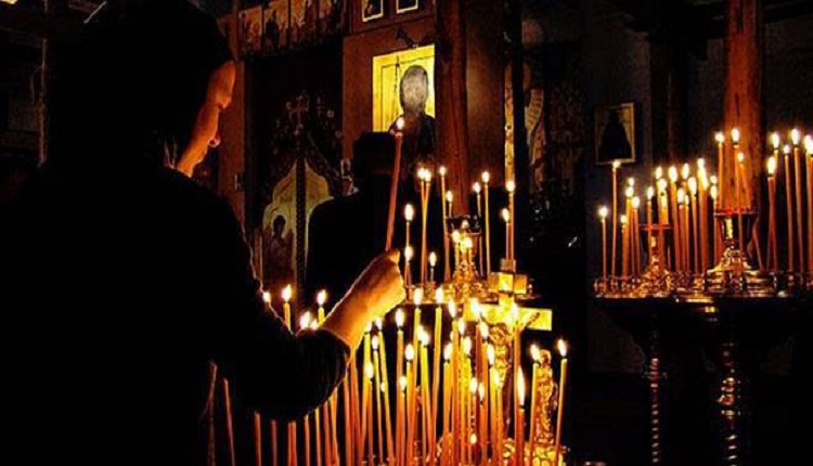 inside Orthodox church lighting candles